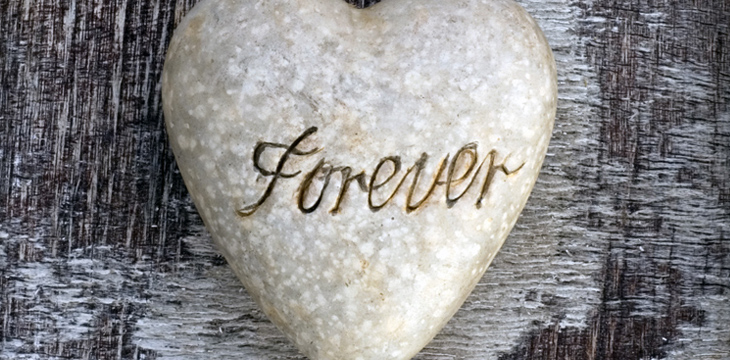 Black wooden frame with a white stone heart with the word Forever carved into the stone