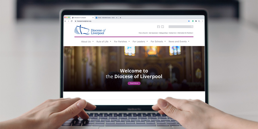 Photo of person's hands using laptop to look at the new Diocesan website